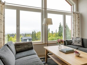 A modern living room with a sofa, a coffee table, and a lamp.