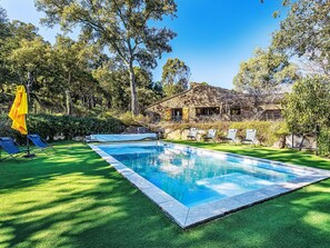 A swimming pool with a stone house in the background, surrounded by trees and a well-maintained lawn. - La Bastide Neuve by Interhome (La Môle)