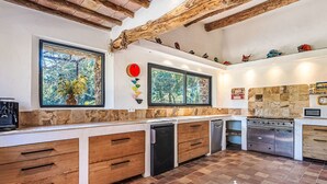 A modern kitchen with wooden cabinets, a built-in oven, and a stone backsplash. - La Bastide Neuve by Interhome (La Môle)