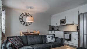 A modern kitchen with white cabinets, a stainless steel refrigerator, and a microwave. - Trillevallen 2 by Interhome (Trillevallen)