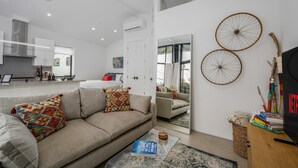 A modern living room with a sofa, a coffee table, and a TV stand with books.