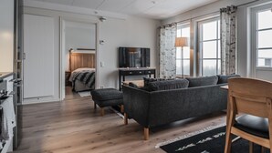 A modern living room with a sofa, a TV, and a dining area. - Trillevallen 1 by Interhome (Trillevallen)