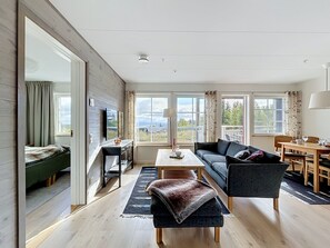 A modern living room with a sofa, coffee table, and dining area. - Trillevallen 1 by Interhome (Trillevallen)