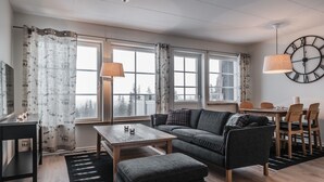 A modern living room with a sofa, coffee table, and dining area. - Trillevallen 1 by Interhome (Trillevallen)