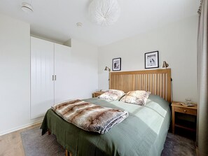 A bedroom with a bed, a wardrobe, a bedside table, and a nightstand. - Trillevallen 1 by Interhome (Trillevallen)