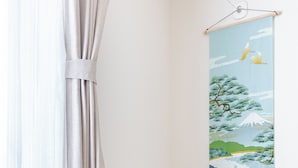 A room with a round wooden table and a white chair, a curtain, and a wall-mounted artwork depicting a nature scene. - 22 min to EXPO,15 min to KITA-Osaka/Umeda: HepFive,KuchuTeien,Kitashinchi (Osaka)