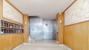 A hallway with wooden paneling, a metal staircase, and a fire exit door. - GuestHost - In Rapallo, a cozy 43 sqm apartment for 3 guests, located on the second floor with an elevator (accessible via steps). Featuring a balcony and reserved parking, a real plus in the city. Rapallo, the heart of the Ligurian Riviera, offers sea,  (Rapallo)