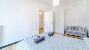 A room with a bed, a sofa, a door, and a hallway. - GuestHost - In Rapallo, a cozy 43 sqm apartment for 3 guests, located on the second floor with an elevator (accessible via steps). Featuring a balcony and reserved parking, a real plus in the city. Rapallo, the heart of the Ligurian Riviera, offers sea,  (Rapallo)