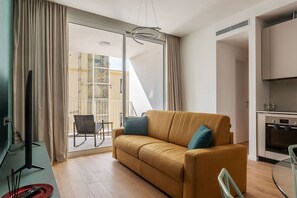 Un salon moderne avec un canapé, un téléviseur et un coin repas.