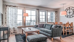 Ein modernes Wohnzimmer mit einer Couch, einem Couchtisch und einem Essbereich mit Stühlen und einem Tisch.