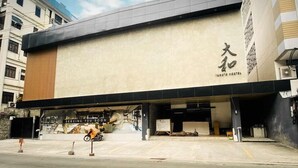A modern building with a sign that reads "KAMATA HOTEL" and "SERVING YOU SOON". - Yamato Hostel (Pasay)