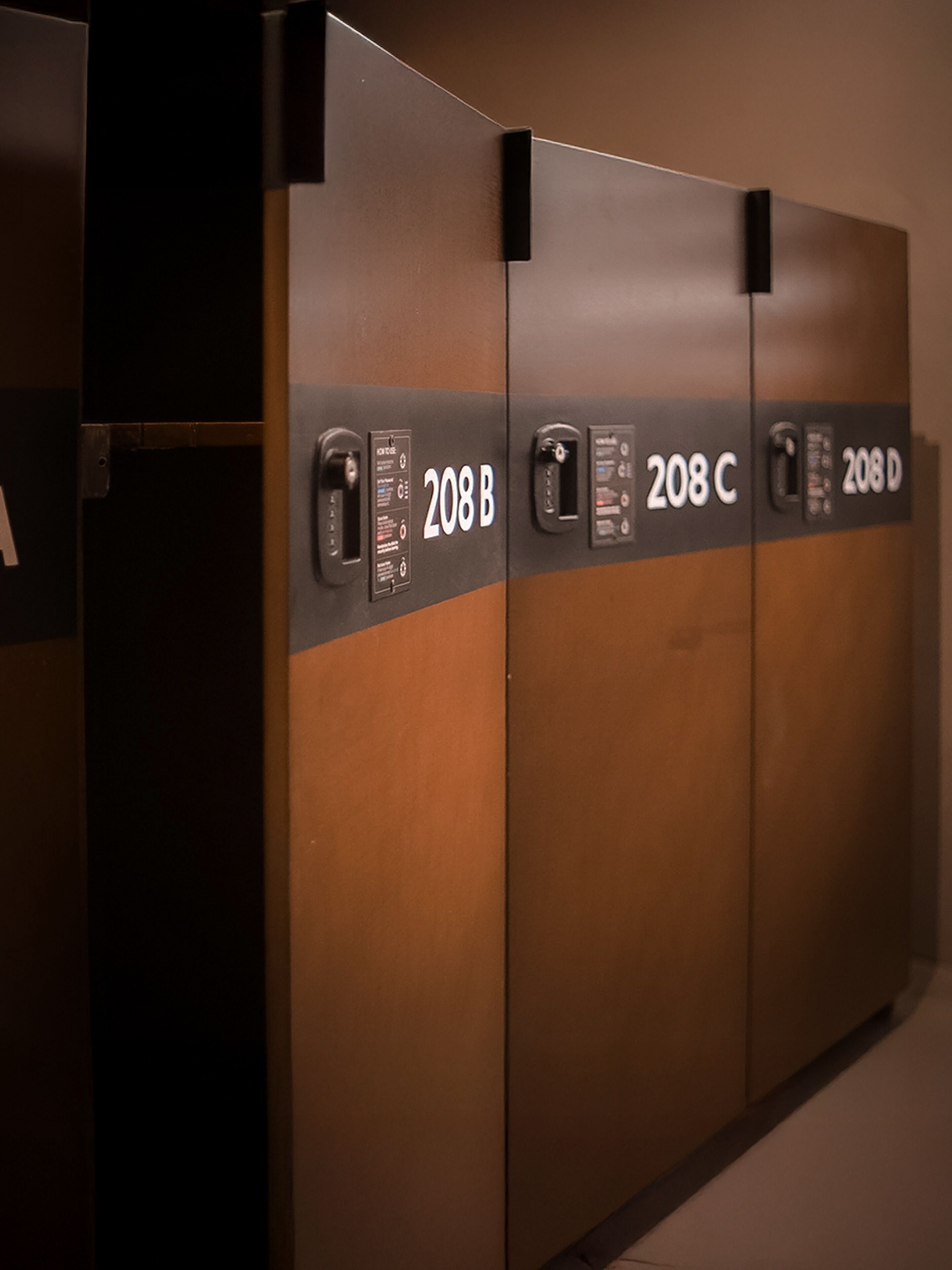 Une rangée de quatre portes d’ascenseur portant les numéros 208B, 208C et 208D.