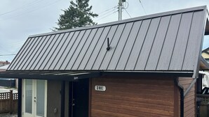 En etagers bygning med brun facade og metal tag.