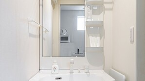 A bathroom with a white sink, a mirror, a towel rack, and a toilet.