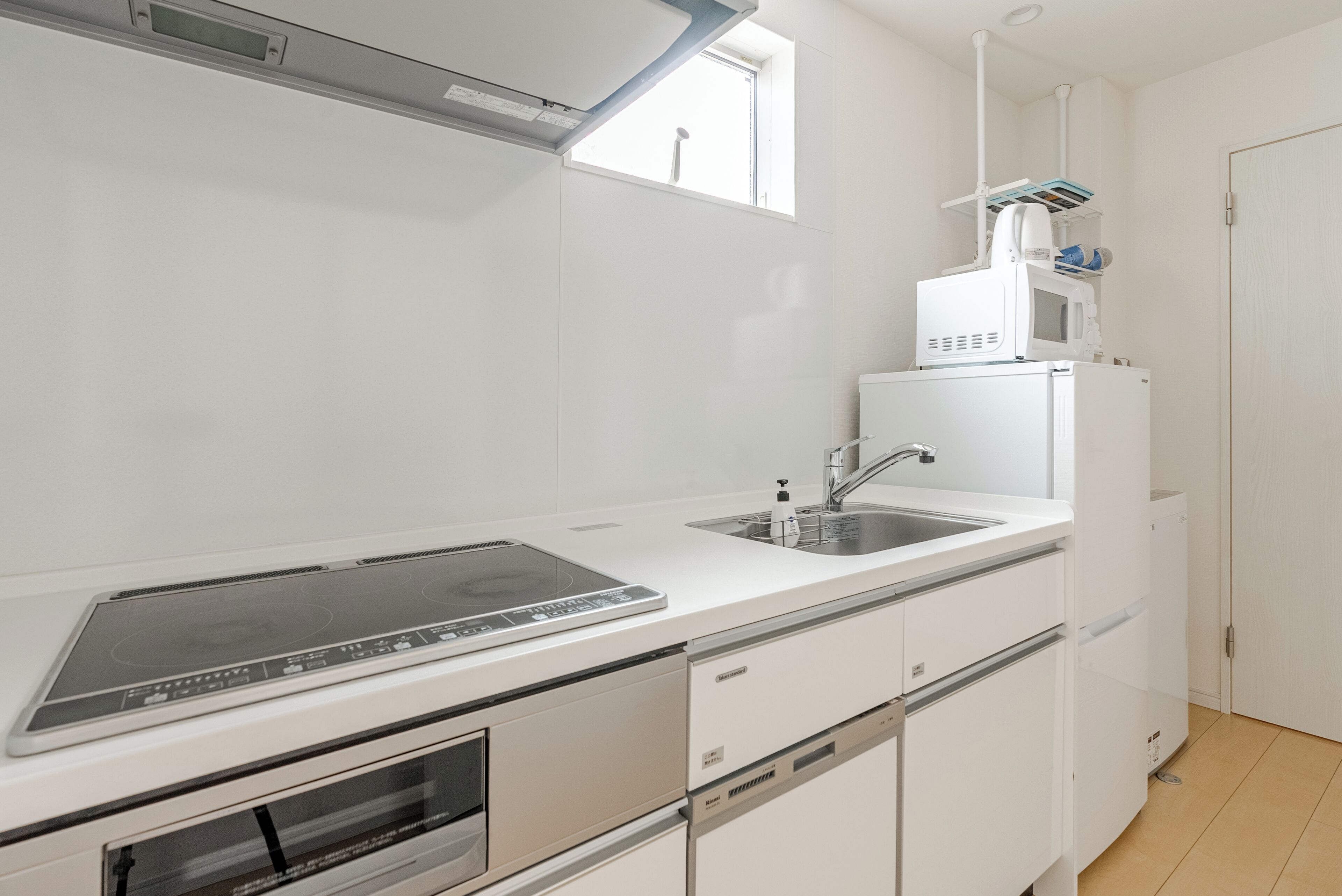 A modern kitchen with a built-in oven, a microwave, and a sink.