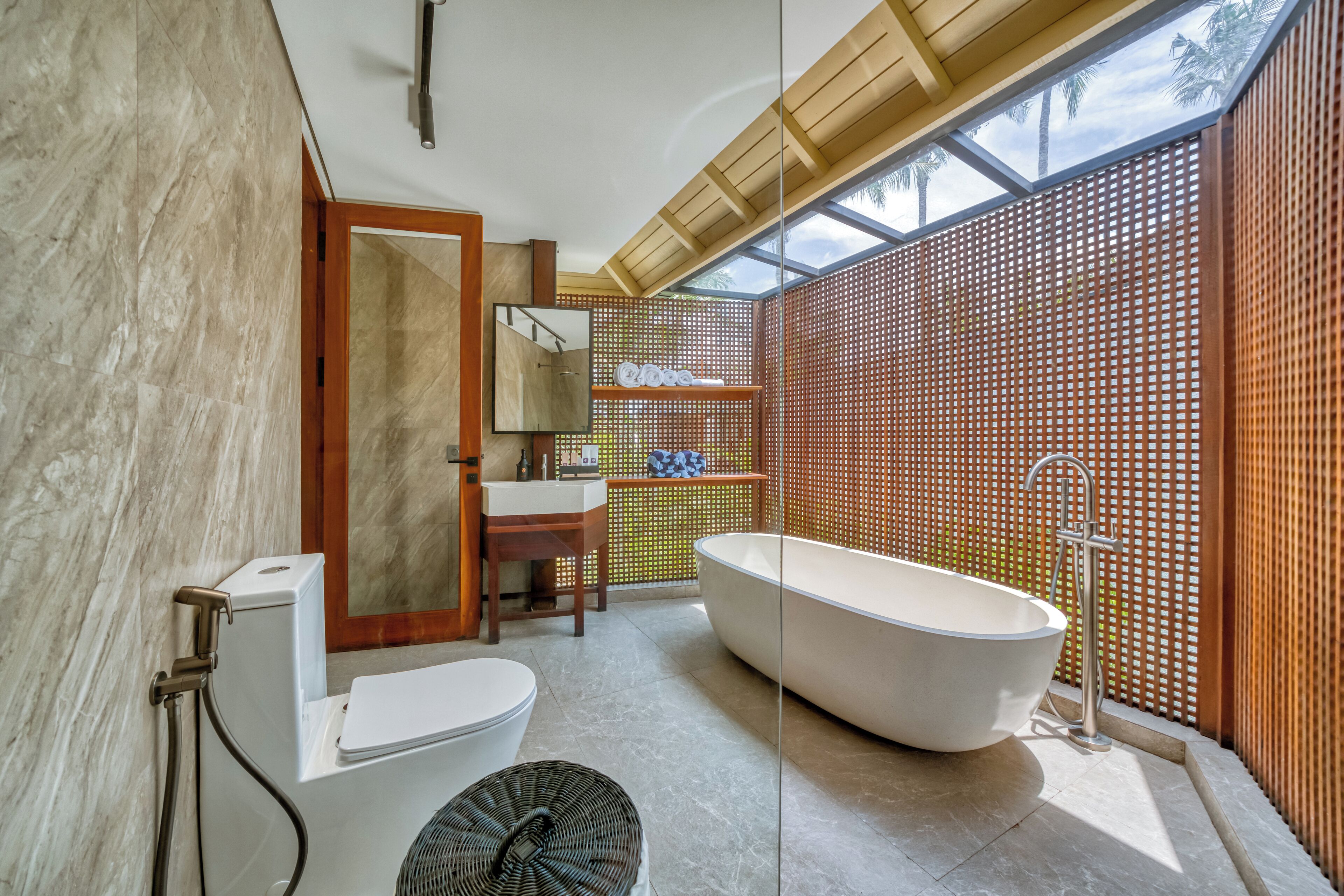 Ein modernes Badezimmer mit einer freistehenden Badewanne, einer Toilette und einem Waschbecken.