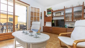 Un coin repas avec une table ronde, des chaises et une vue sur l’extérieur, accessible par une porte vitrée.