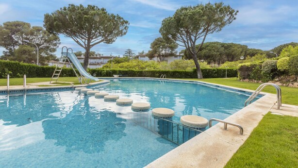 Une piscine avec un toboggan, des marches et une échelle.