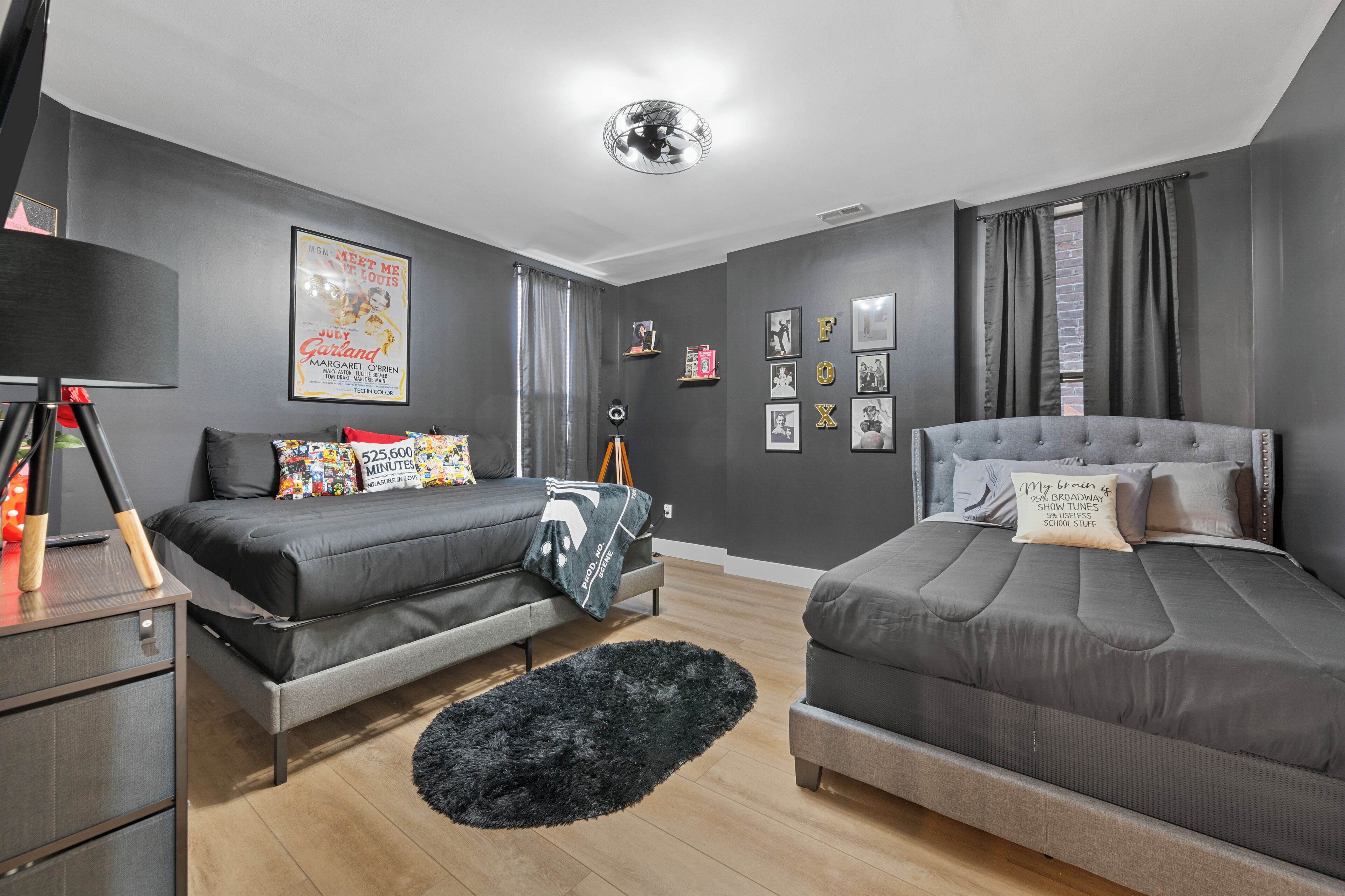 Une chambre moderne avec deux lits, un bureau et un tapis noir.