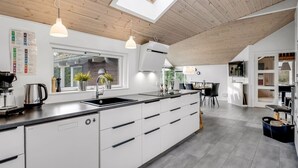 Una cocina moderna con tragaluz, armarios blancos y una isla central.