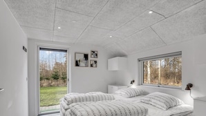 Un dormitorio moderno con una cama grande, una ventana y vistas al exterior.