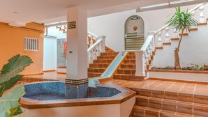 A pool area with a hot tub, stairs, and a staircase leading to an upper level. - Kaora Ocean View Apartment (Costa Adeje)