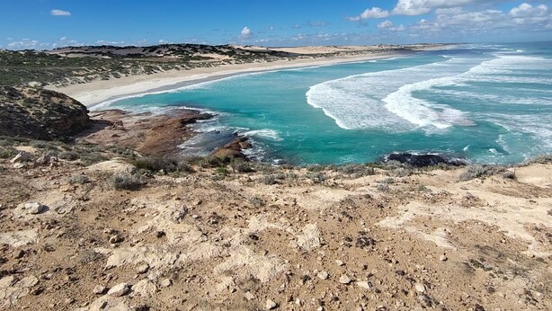 A coastal landscape with a sandy beach, rocky terrain, and clear blue waters. - Elliston Waterloo Bay Tourist Park  (Elliston)