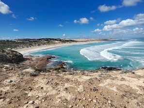 A coastal landscape with a sandy beach, rocky terrain, and clear blue waters. - Elliston Waterloo Bay Tourist Park  (Elliston)
