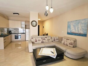 Una sala moderna con un sofá, una mesa de centro y un cuadro de veleros en la pared.