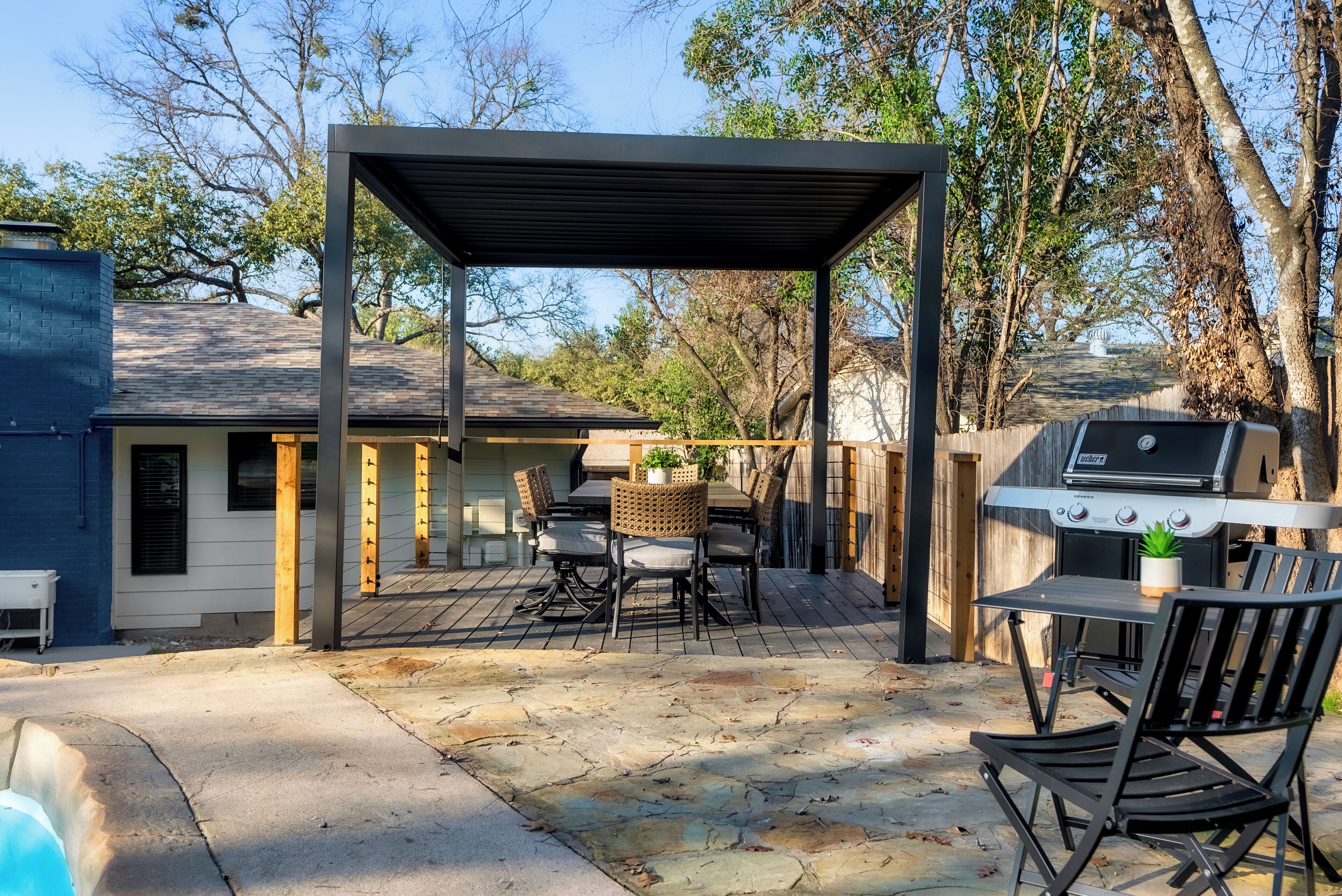 A covered patio with a grill and seating area.