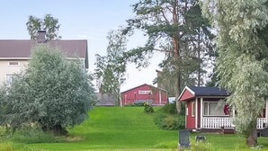 A lakeside property with a dock, a small red house, and a larger building in the background. - Vacation home Jutila by Interhome (Jämijärvi)