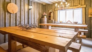 A rustic wooden interior with a large wooden table, benches, and a chandelier. - Vacation home Jutila by Interhome (Jämijärvi)