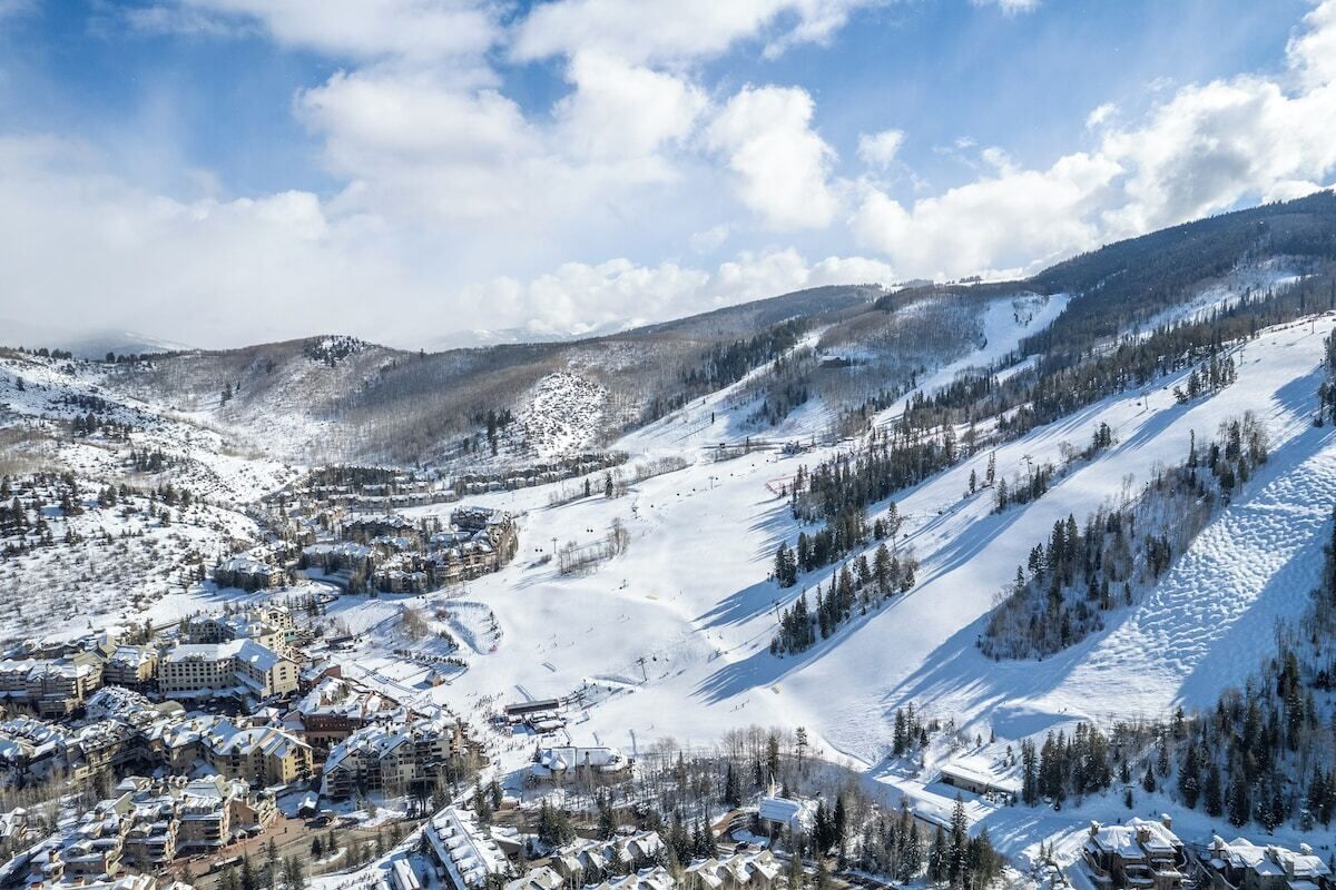 A snow-covered mountainous area with buildings and ski slopes.