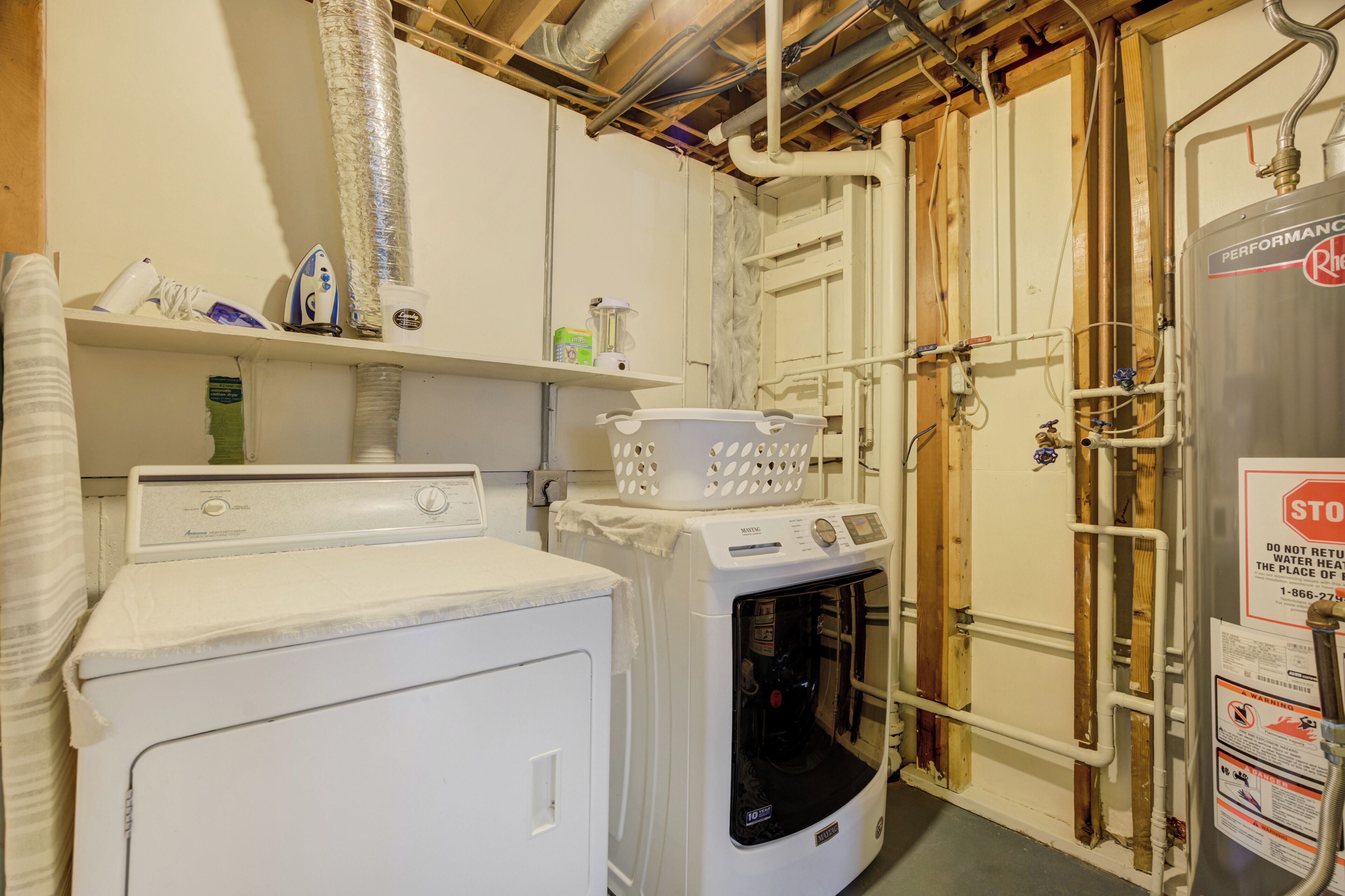 A laundry room with a washer, dryer, and a water heater.