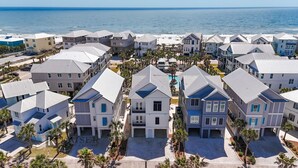 A coastal residential area with multiple two-story houses, each with a flat roof and a small front porch. - Welcome to Tide and True | New Luxury Beachfront Retreat | Cottages at Romar 17 (Orange Beach)
