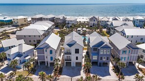 A coastal residential area with multiple two-story houses, each with a flat roof and a small front porch.