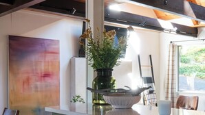 Eine moderne Küche mit einem grünen Schrank, einer weißen Arbeitsplatte und einer Blumenvase.