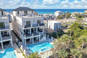 A multi-story building with a pool, balconies, and a view of the ocean.