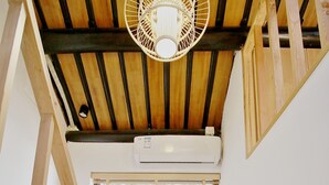A staircase leading to a room with a wooden ceiling, a window with blinds, and an air conditioning unit. - shierpusu (Shaoxing)