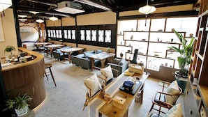 A spacious interior with multiple seating areas, a reception desk, and large windows providing natural light. - shierpusu (Shaoxing)