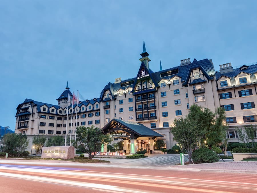 A large, multi-story hotel with a traditional European architectural style, featuring a prominent clock tower and multiple balconies.