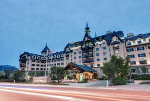 A large, multi-story hotel with a traditional European architectural style, featuring a prominent clock tower and multiple balconies.