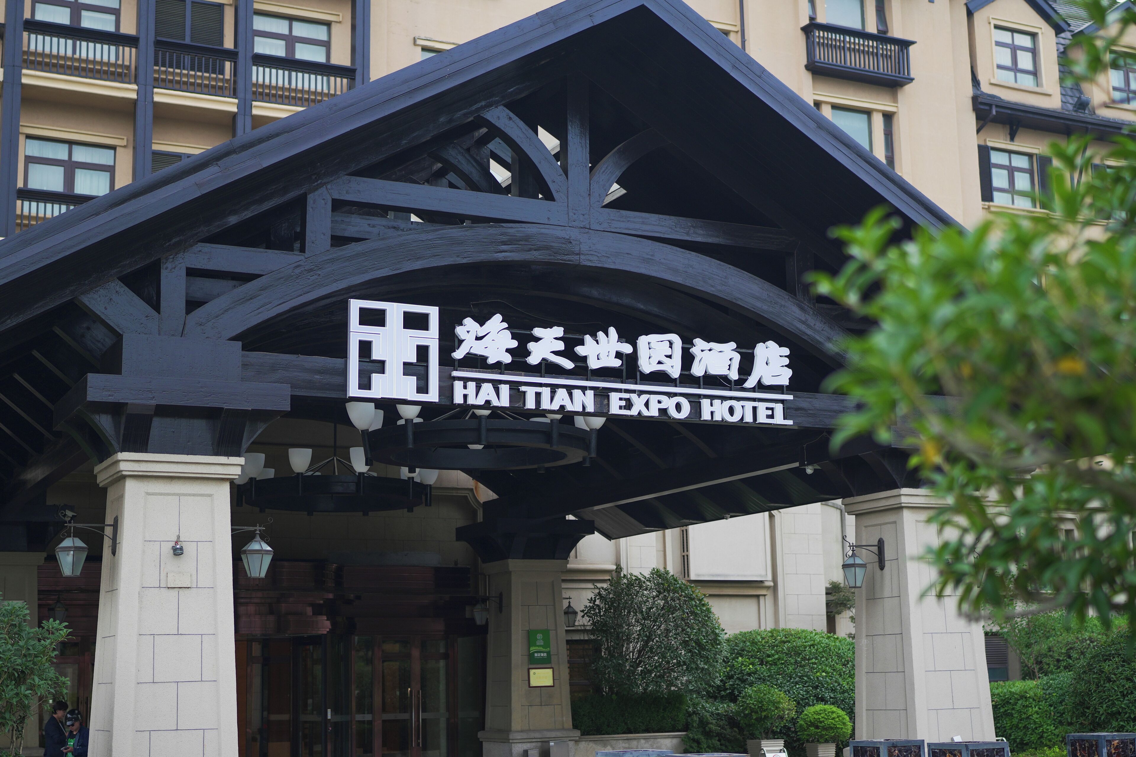 De ingang van het Hai Tian Expo Hotel, met een opvallend bord en een traditionele architectuur.