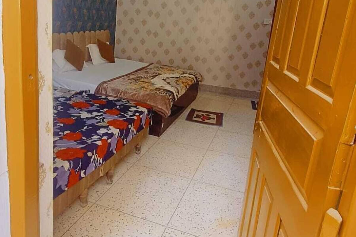 A bedroom with a bed, a wardrobe, and a ceiling fan.