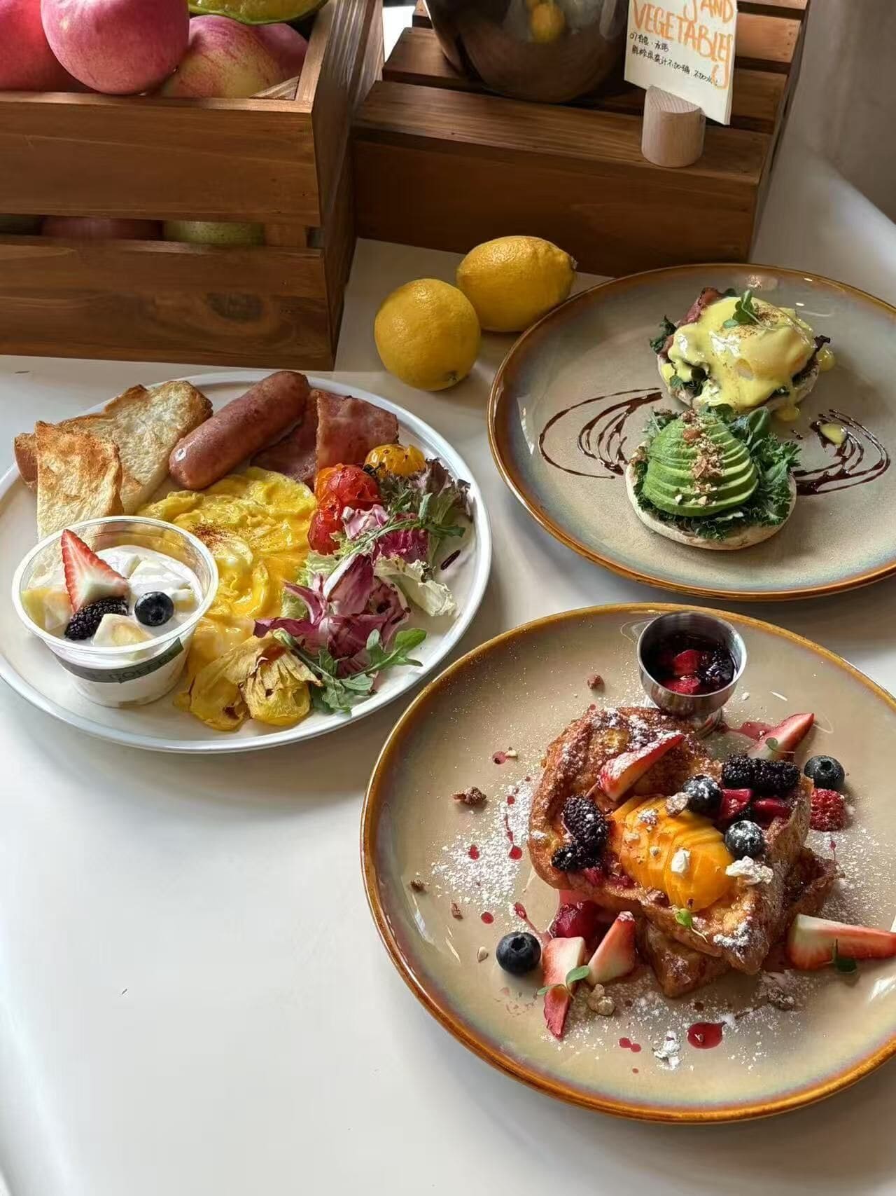 A breakfast spread with various dishes including eggs, toast, sausages, and fresh fruits.