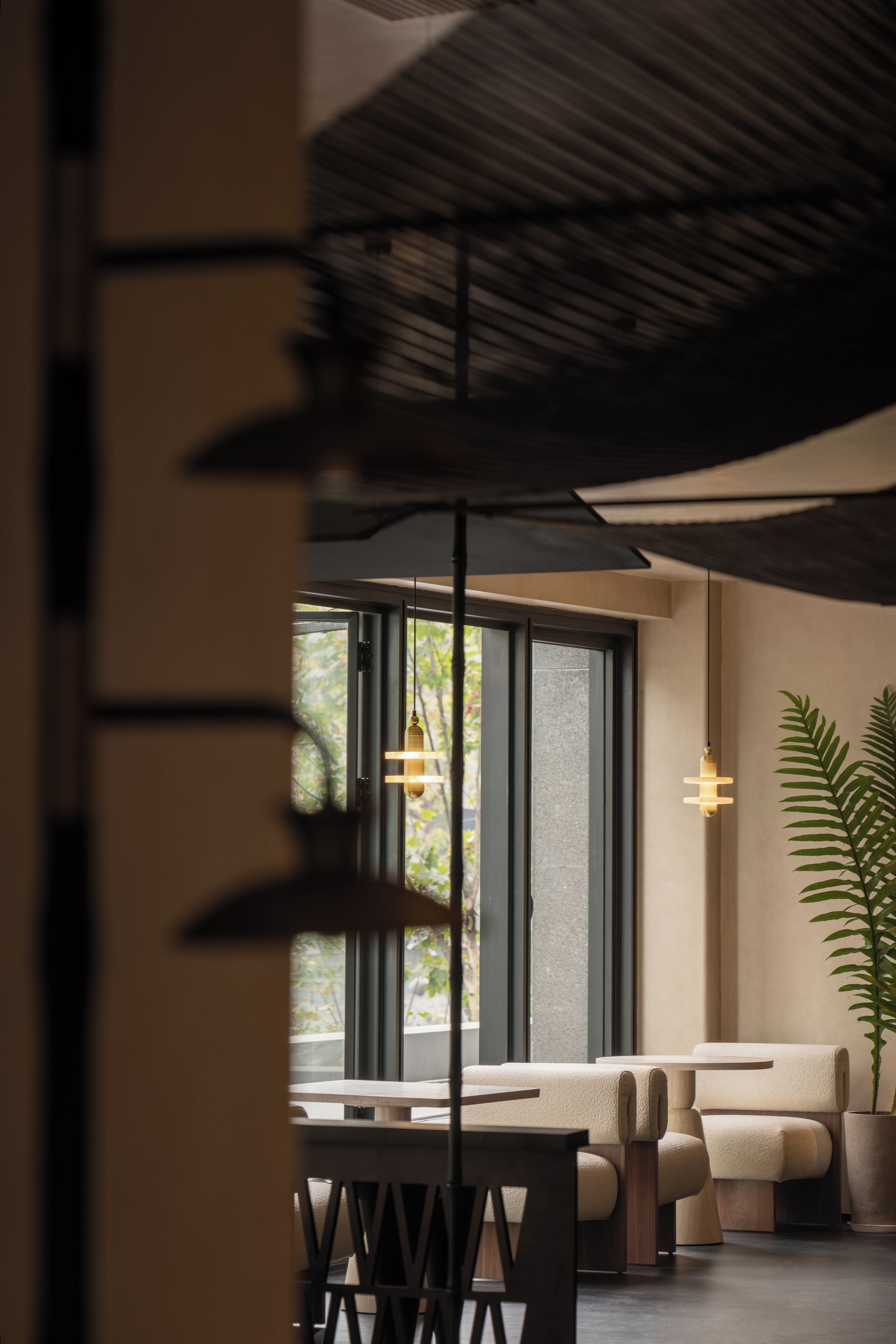 Un intérieur moderne avec un canapé, des tables et une plante en pot.