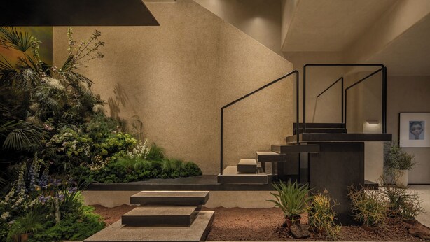 Un escalier moderne au design minimaliste, entouré d’une végétation luxuriante et de plantes.
