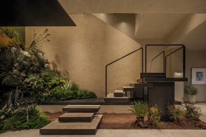 A modern staircase with a minimalist design, surrounded by lush greenery and plants. - BUYUAN HOTEL (Chengdu)
