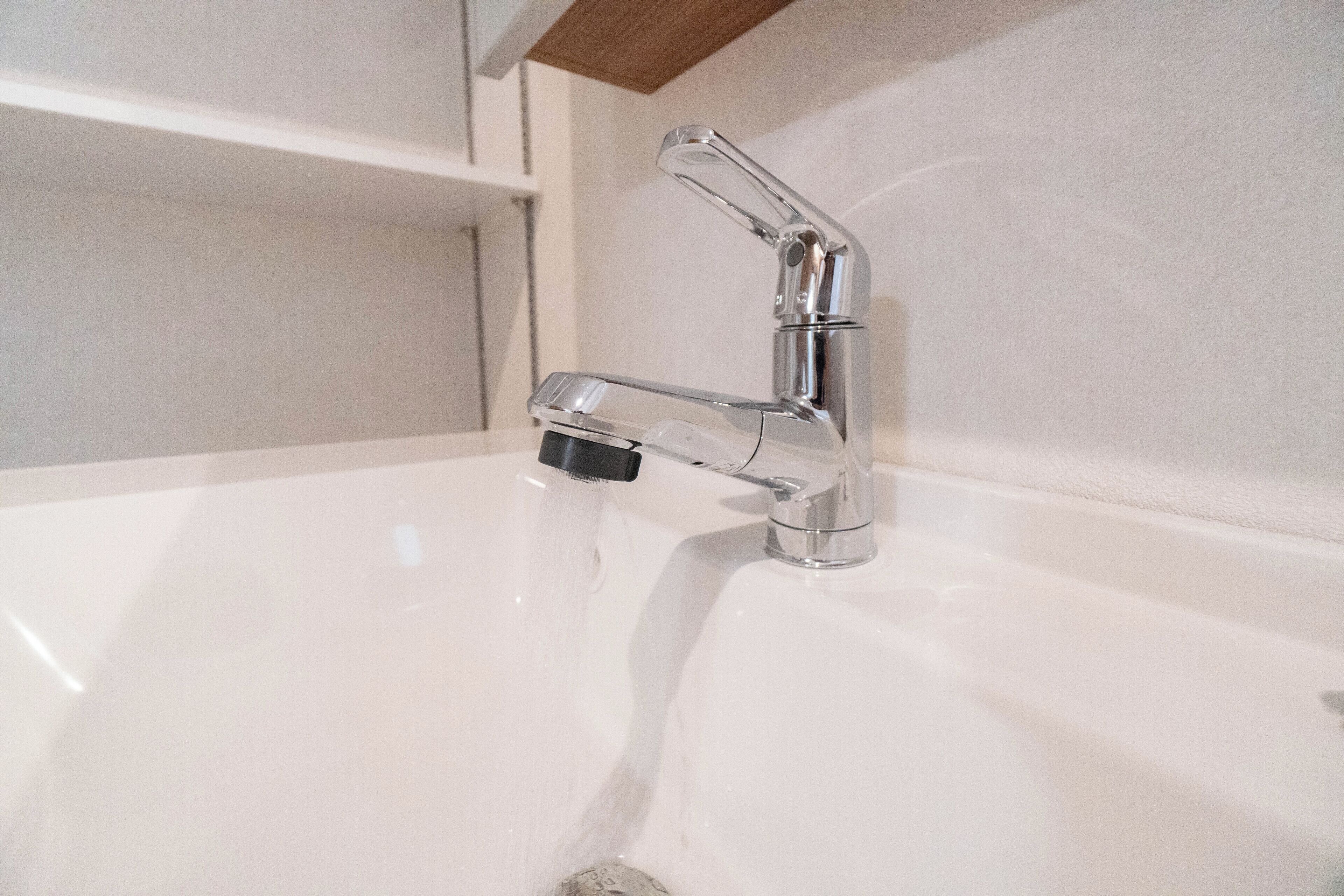 A modern bathroom with a chrome faucet and a white sink.