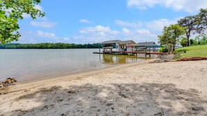 Une propriété au bord du lac, dotée d’un quai, d’une structure abritée et d’une plage de sable.